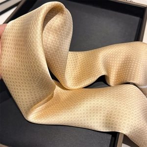 Close-up of champagne satin scarf featuring fine texture and elegant shimmer details