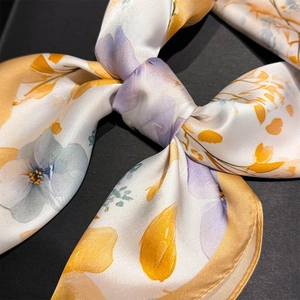 Close-up of floral print silk scarf with fine rolled edges and satin luster finish