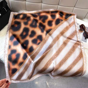 Detail of leopard and stripe print square silk scarf with elegant satin sheen and textures