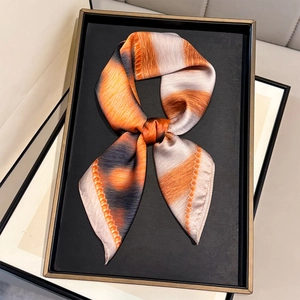 Macro detail of gradient leopard silk scarf tied on a luxury display tray