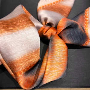 Close-up of leopard and stripe print silk scarf with orange and grey gradient textures