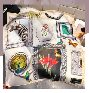 Détail d'un foulard en soie aux imprimés artistiques sur un fond en peluche blanc