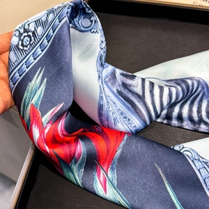 Gros plan d'un foulard en soie à imprimé floral et zèbre montrant un drapé doux et satiné