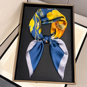 Sciarpa di seta con fiori gialli su sfondo blu scuro in un vassoio nero elegante