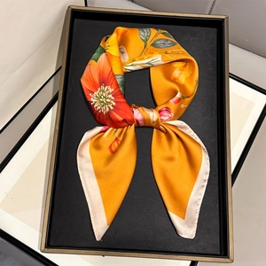 Dettaglio di un foulard in seta con stampe floreali di ibisco arancione su vassoio
