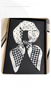 Detail of silk-like square scarf with classic houndstooth and star pattern on display