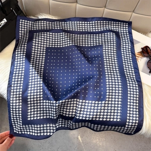 Detail of navy blue houndstooth silk scarf showing fine twill texture and satin finish