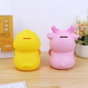 Rear view of animal coin banks with coin slots on a desk with plants and a calendar