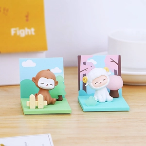 Detailed view of monkey and sheep figurines with colorful forest scenery backdrops
