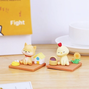 Close-up of resin shiba inu and chick figurines with cute house on a sunny office desk