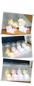 Close-up of glowing animal night lights including shiba and pig on a laptop keyboard
