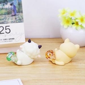 Detail of cute cat and sheep night lights with colorful glass tails on wooden desk
