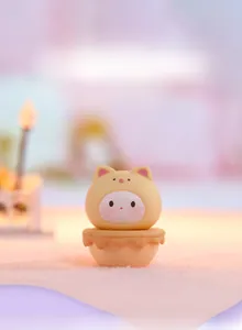 Macro detail of cute yellow cat tumbler ornament with soft silicone texture and round base