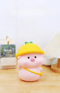 Pink piggy bank with yellow hat and bag on wooden desk in cozy home setting