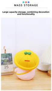 Pink cartoon pig piggy bank with yellow hat and top coin slot on a wooden table