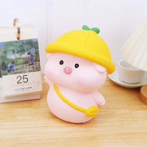 Cute pink pig piggy bank with yellow hat and bag on a warm wooden desk for kids