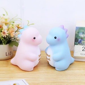 Süße Dinosaurier-Spardosen in Rosa und Blau mit Sweet Heart-Schriftzug auf Holzschreibtisch