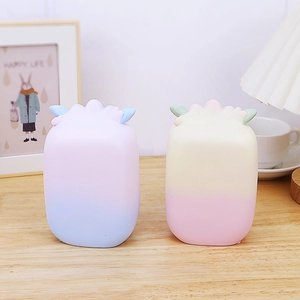 Close-up of gradient pastel squishy toys on a wooden table with soft ambient lighting