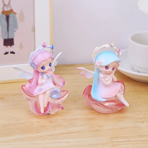 Detailed view of pink and blue resin flower fairy figurines with delicate wings on petal bases