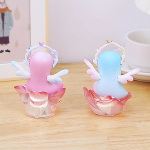 Rear view of pink and blue angel flower fairy figurines on a wooden bedside table