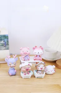 Gros plan de mignonnes figurines d'animaux en résine avec porcs et chats sur un bureau