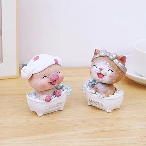 Gros plan de figurines d'animaux en résine dans de mini baignoires sur un bureau
