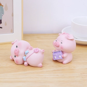 Détail de deux mignonnes figurines de cochons roses en résine sur un bureau
