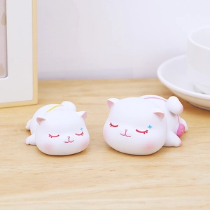 Détail de deux mignonnes figurines de chats blancs en résine sur un bureau