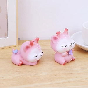 Détail de deux figurines de cerf rose mignon avec bois en cœur sur un bureau