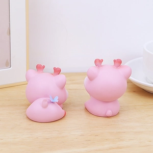 Vue détaillée de figurines cerfs roses avec fleurs sur un bureau ambiance chaleureuse