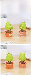 Close-up of cute green resin bear ornaments with spring necks on desk