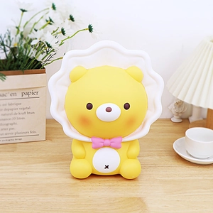 Cute yellow cartoon bear piggy bank with pink bow tie in a cozy home decor setting