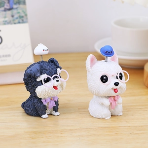 Detalle de figuras de perros teddy y pomerania con gafas para tablero de automóvil