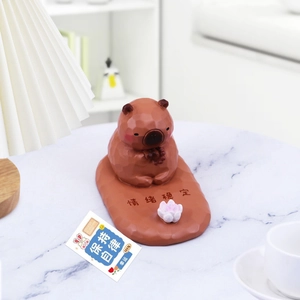 Geometric Capybara desk ornament and phone holder with a lotus on a marble surface