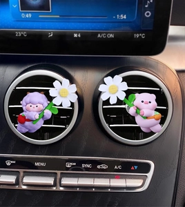 Cute cartoon pig and sheep car air vent clips holding daisies on a dashboard