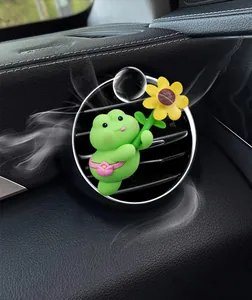 Cute green frog cartoon air vent clip air freshener with flower detail on car dashboard
