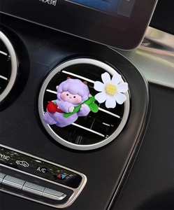 Close-up of a cute purple sheep car air vent clip with daisy on black interior vent