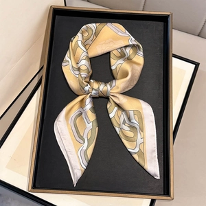 Vintage geometric chain print silk scarf in yellow and grey tied in elegant loop