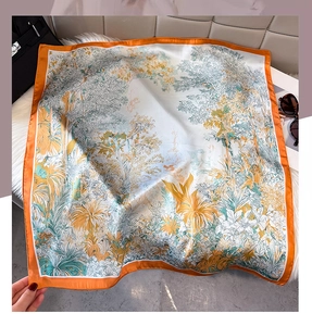 Macro view of French tropical palm print silk scarf with luxury accessories on white faux fur