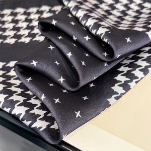 Detail shot of houndstooth silk scarf showing smooth texture and star patterns
