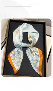 Detail of silk scarf featuring French rainforest floral print with bright orange hem finish