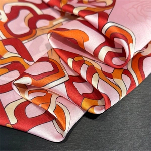 Detail of silk scarf showing pink geometric chain patterns and rose floral texture