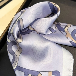 Close-up of silk scarf with rose floral pattern, geometric lines and hand-rolled edges