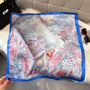 Close-up of French rainforest print silk scarf on plush background with accessories