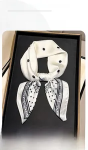 Detail of silk scarf with black polka dots and geometric retro border on display tray