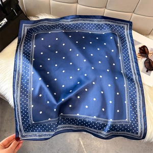 Navy blue polka dot silk scarf with floral border on white faux fur and handbag