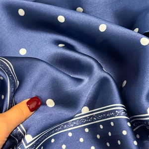 Navy blue silk scarf with white polka dot print and decorative wavy border design