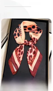 Detail shot of leopard print silk scarf with red edges and soft satin texture fabric