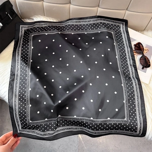 Detail of silk scarf with black and white polka dots and European scroll textures