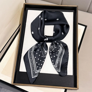 Classic black silk scarf with white polka dots and elegant swirl border in a gift tray